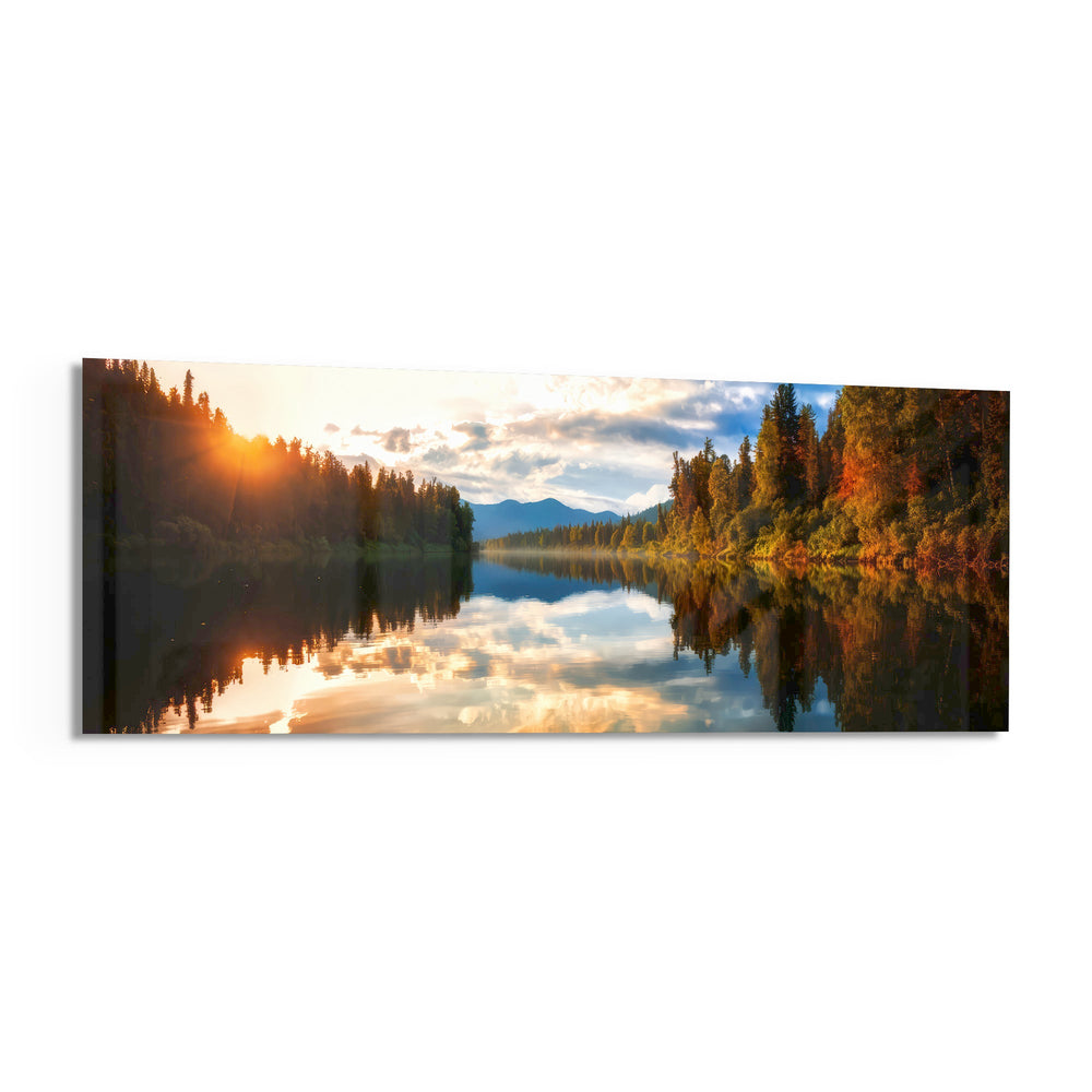 A mirror-calm lake at sunrise reflecting autumn forest, distant mountains, and a glowing cloudy sky. panoramic glass wall art F