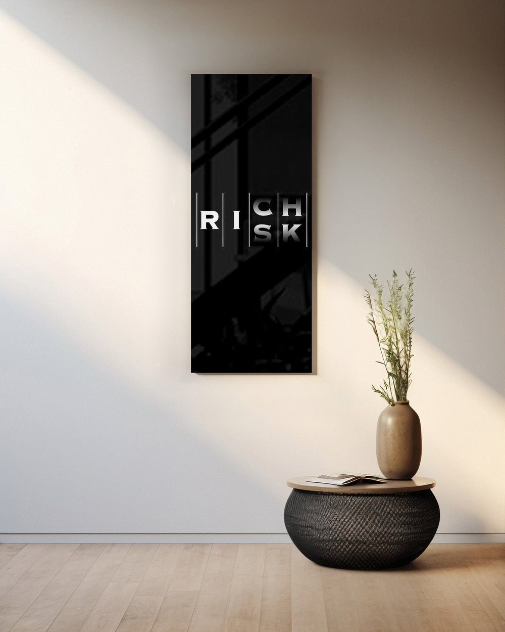 Minimalist black typography panel where the words "RISK" and "RICH" interlock in a single vertical column of white letters. panoramic glass wall art A