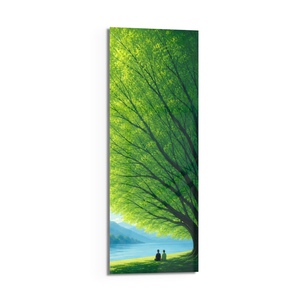 Two small figures sitting together on grass beneath a vast green tree, gazing over a calm blue lake toward distant mountains. panoramic glass wall art D