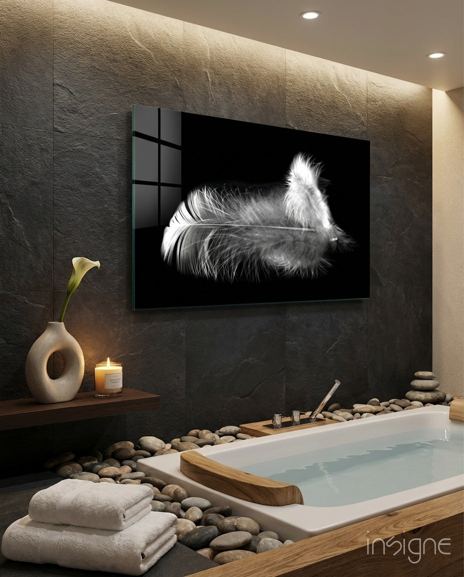Feather glass wall art displayed above a soaking tub in a stone-tiled bathroom