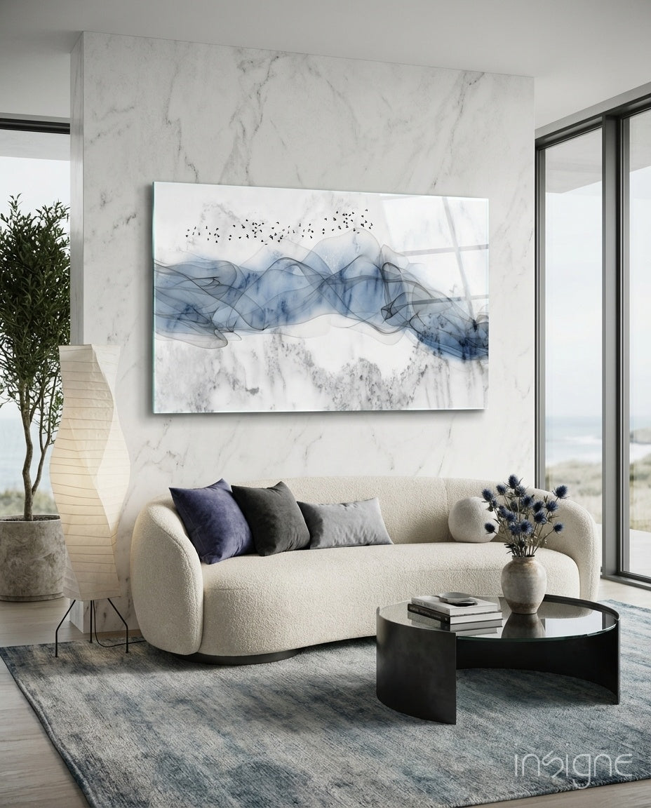 Ink Drift glass wall art displayed above a curved boucle sofa in a coastal living room