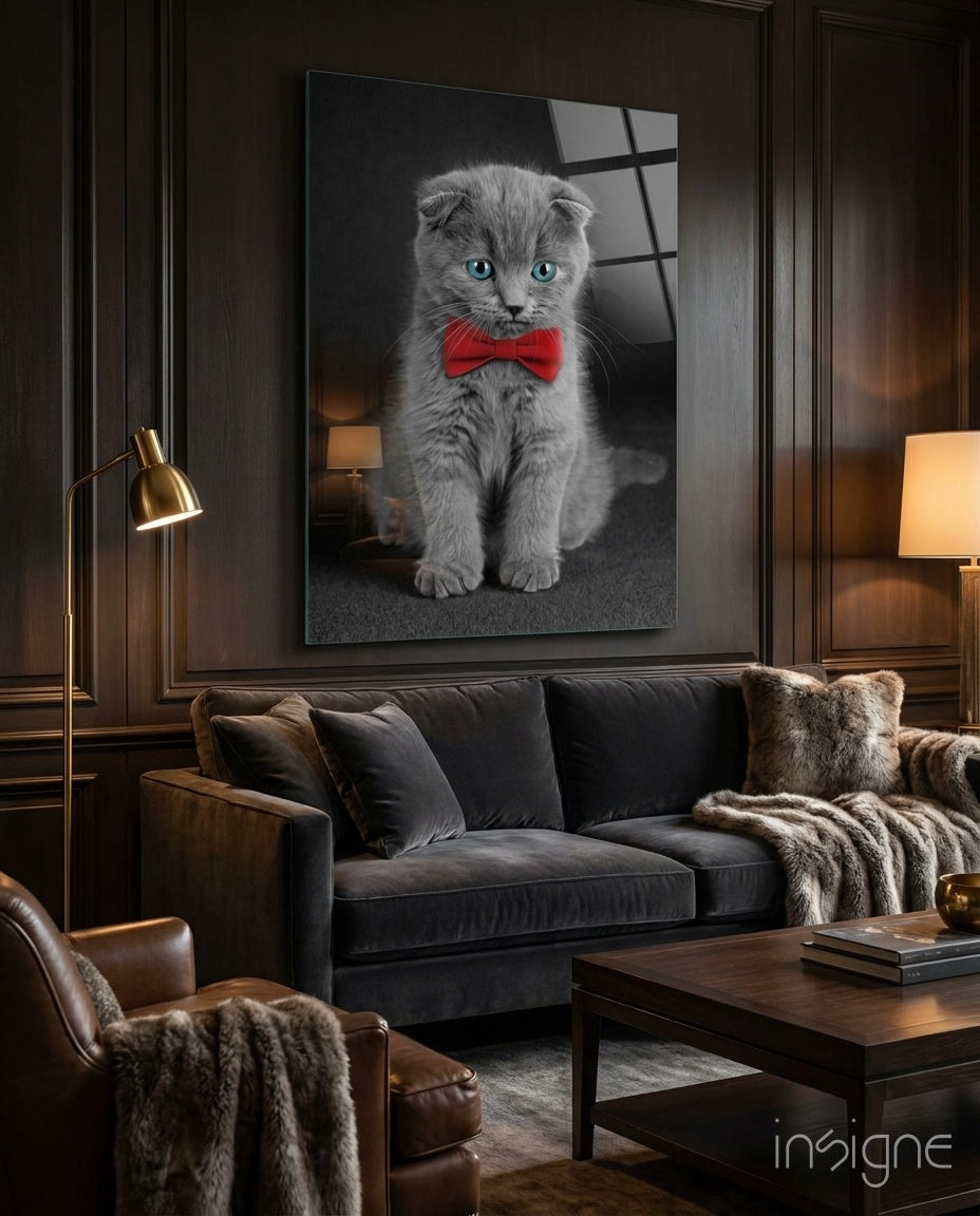 Bow-Tie Kitten glass wall art displayed above a charcoal velvet sofa in a wood-paneled lounge