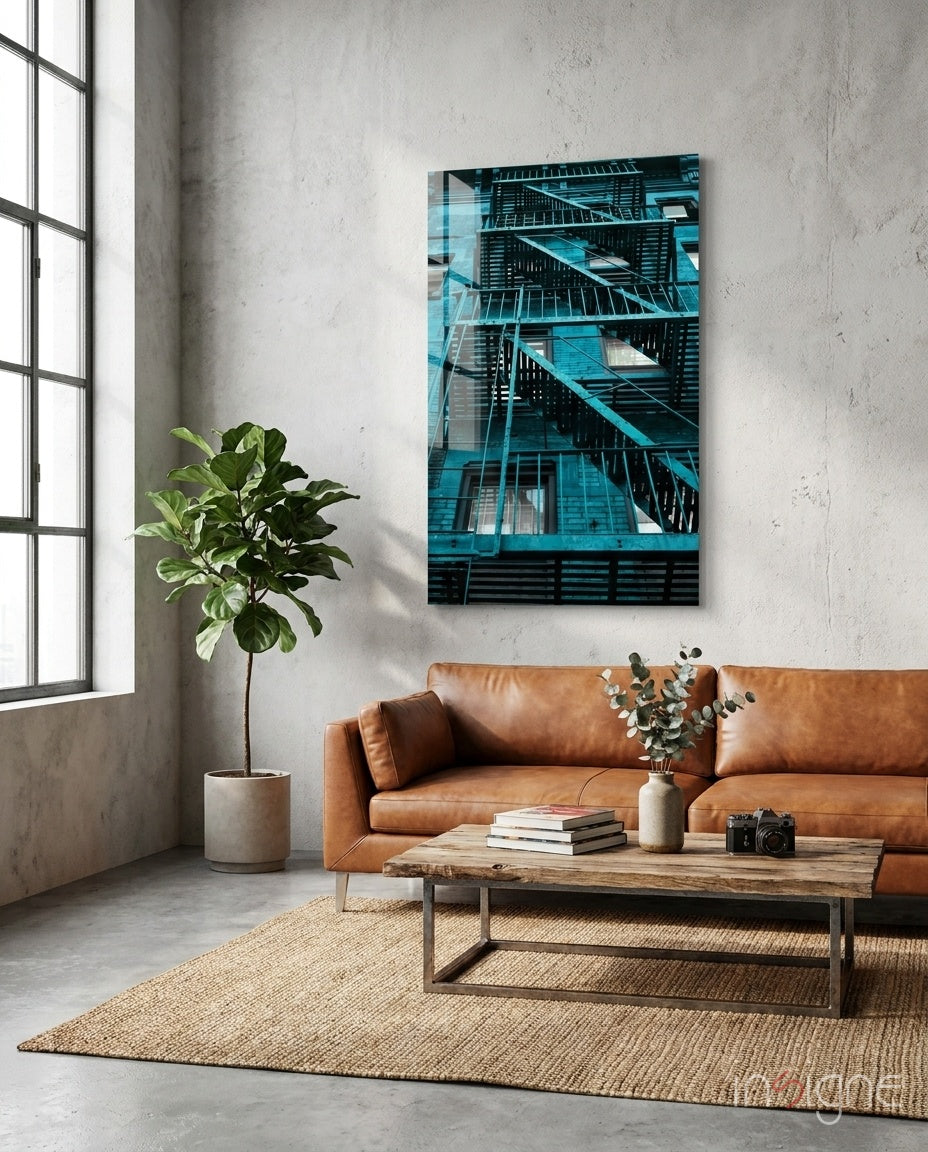 Blue Stairs glass wall art displayed above a cognac leather sofa in a light concrete-walled lounge