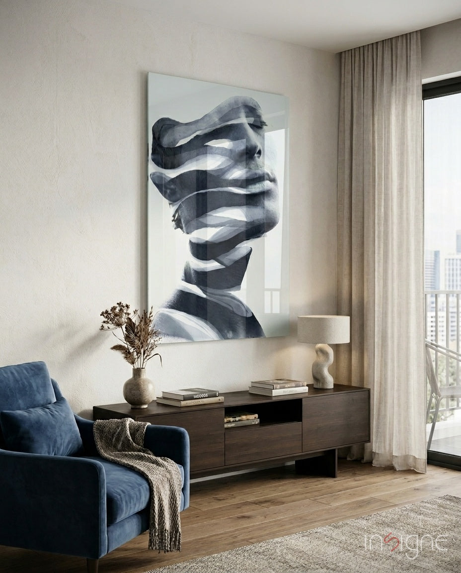 Man glass wall art displayed above a dark wood credenza in a soft white-plaster lounge with navy velvet armchair and pampas vase