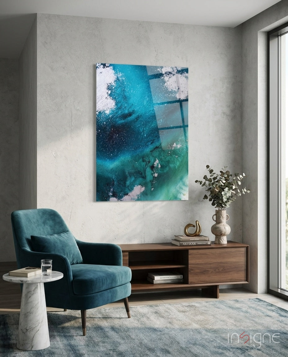 Colors of Abstraction glass wall art displayed above a charcoal sectional in a soft concrete-walled lounge with teal velvet pillows and palm vase