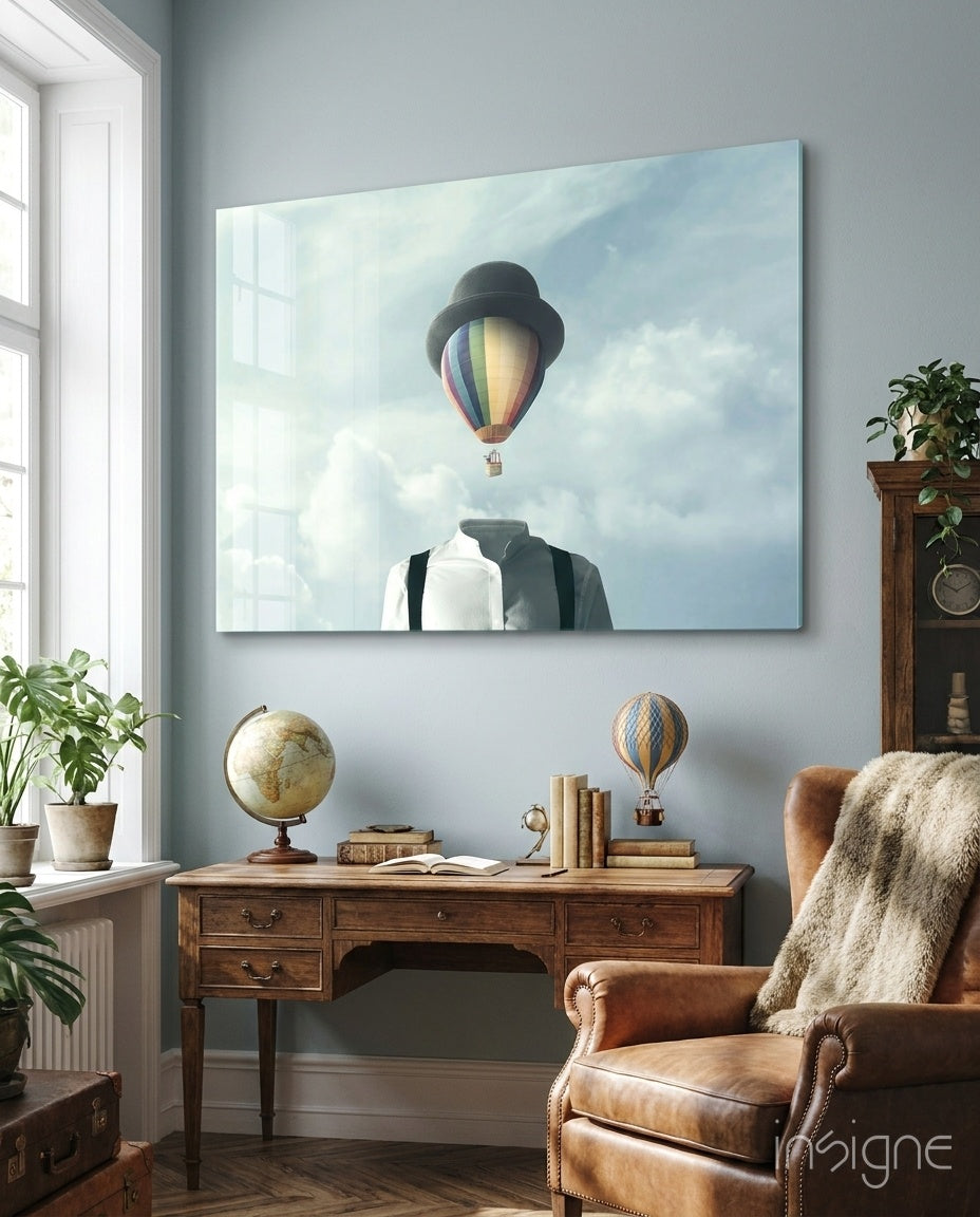 Balloon Heads glass wall art displayed above an antique wood desk in a soft blue-walled study with leather wing chair and antique globe