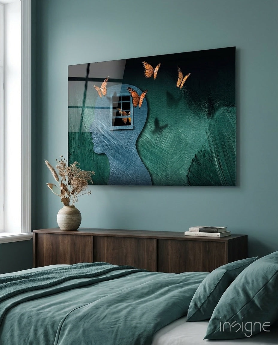 Butterfly Effect glass wall art displayed above a wood credenza in a sage-walled bedroom with teal linen bedding and pampas vase