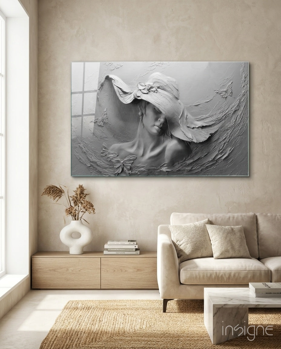Relief Woman glass wall art displayed above a wood credenza in a soft cream-plaster lounge with cream linen sofa and pampas vase