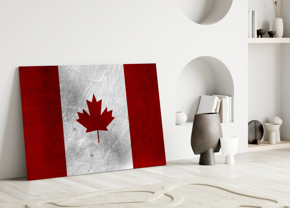 Flag of Canada Flag close-up showing maple leaf on brushed-metal panel between crimson bands