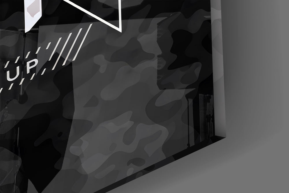 Close-up detail of the blue and silver camo typography behind glass