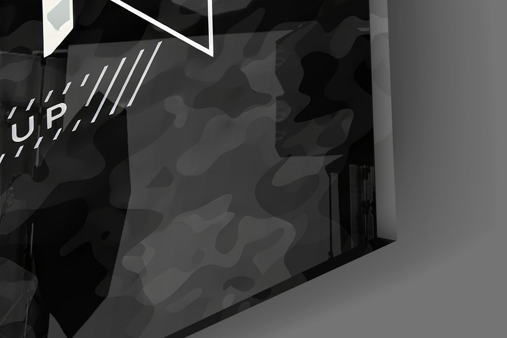 Close-up detail of the gold and silver camo typography behind glass