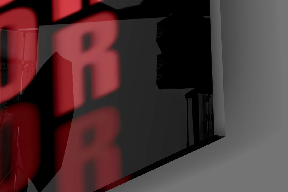 Close-up detail of the scarlet repeated typography behind glass