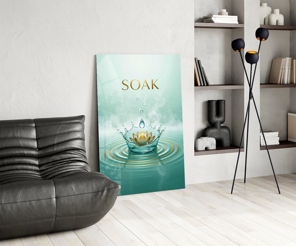 soak golden lotus water crown glass wall art leaning beside a dark leather sofa