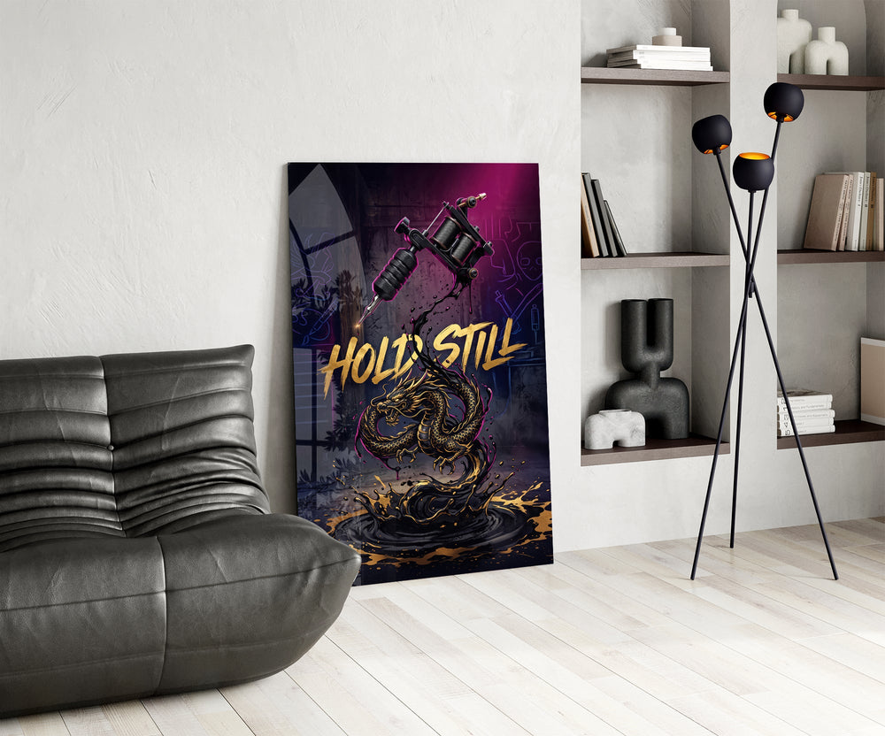 hold still tattoo machine and gold dragon glass wall art leaning beside a dark leather sofa