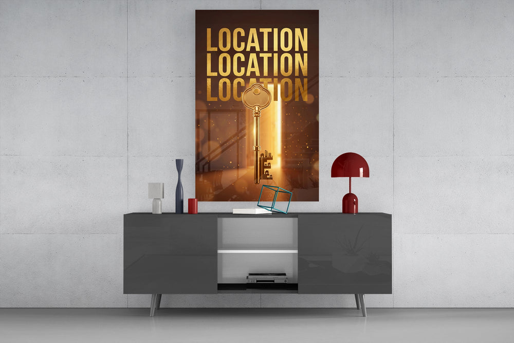 gold real estate key with a skyline glass wall art displayed above a console in a designer interior