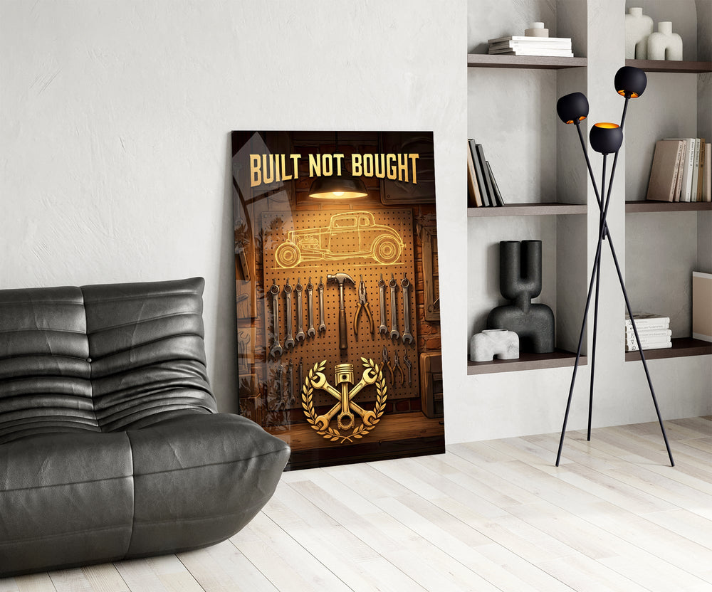 hot rod garage tool wall glass wall art leaning beside a dark leather sofa