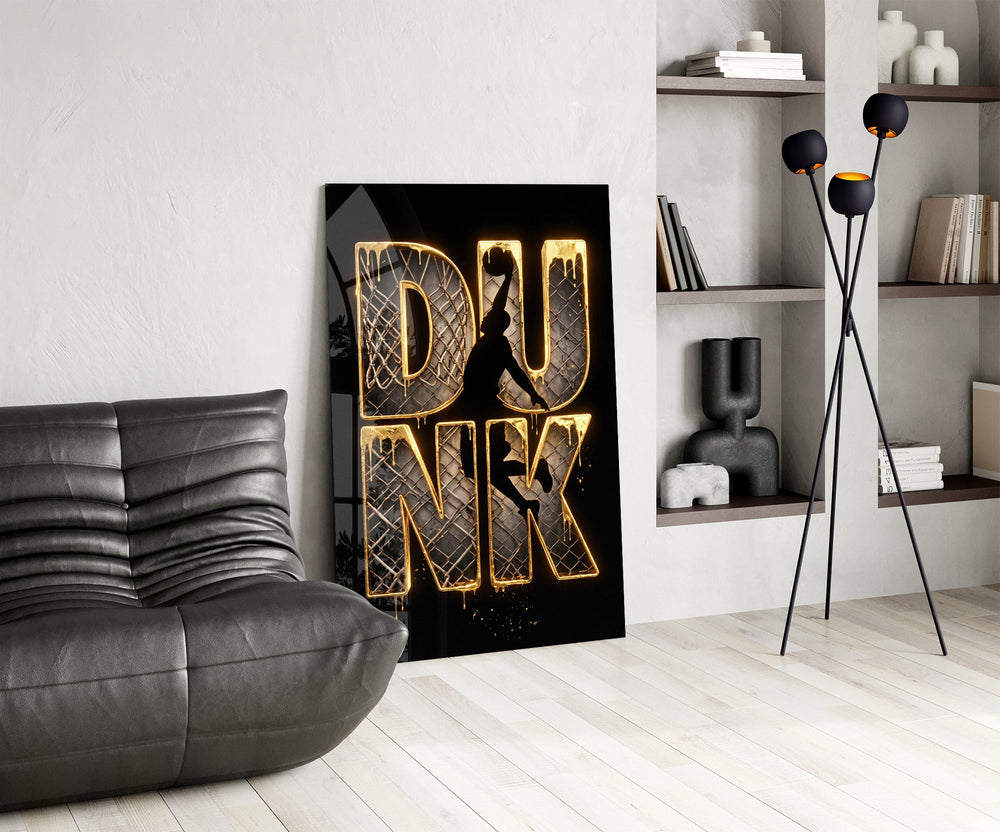 gold Dunk basketball typography glass wall art leaning beside a dark leather sofa