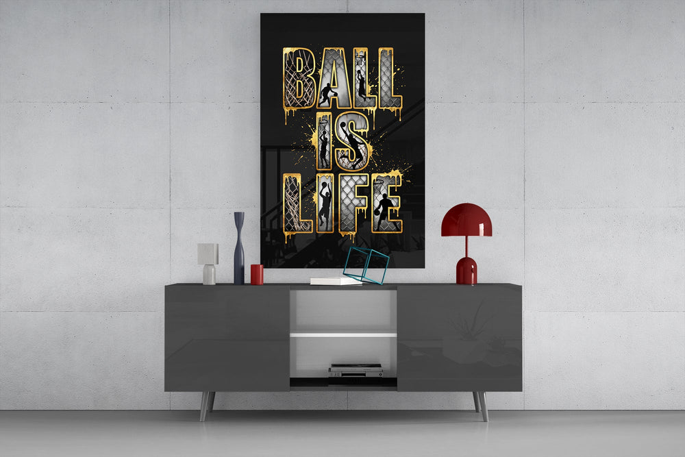 gold Ball Is Life basketball typography glass wall art displayed above a console in a designer interior