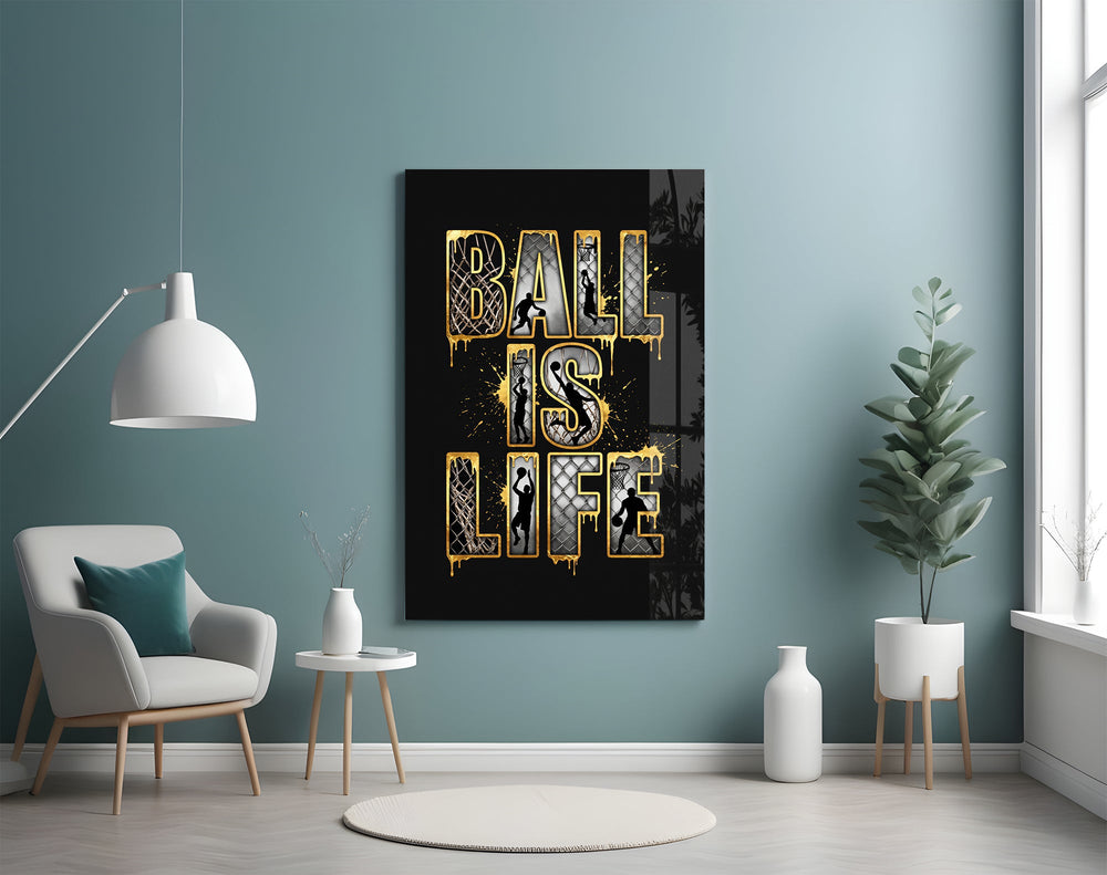 gold Ball Is Life basketball typography glass wall art styled above an armchair in a reading corner