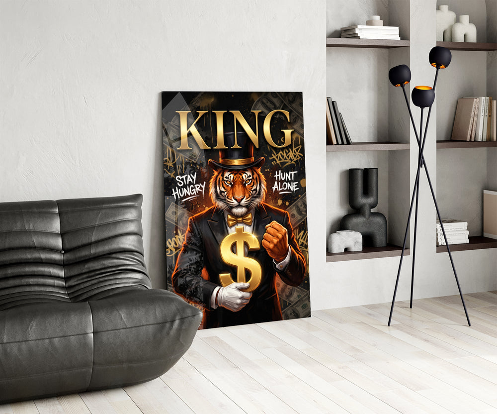 suited tiger with a gold dollar sign glass wall art leaning beside a dark leather sofa
