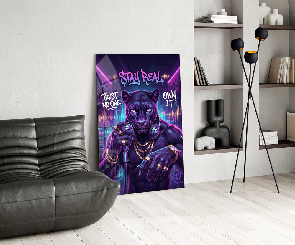 stay real neon panther rapper glass wall art leaning beside a dark leather sofa