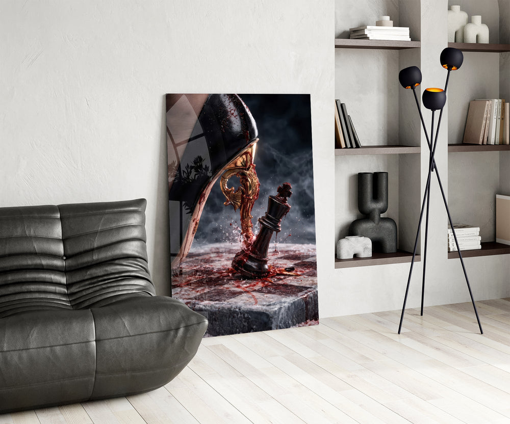 stiletto heel crushing a chess king glass wall art leaning beside a dark leather sofa