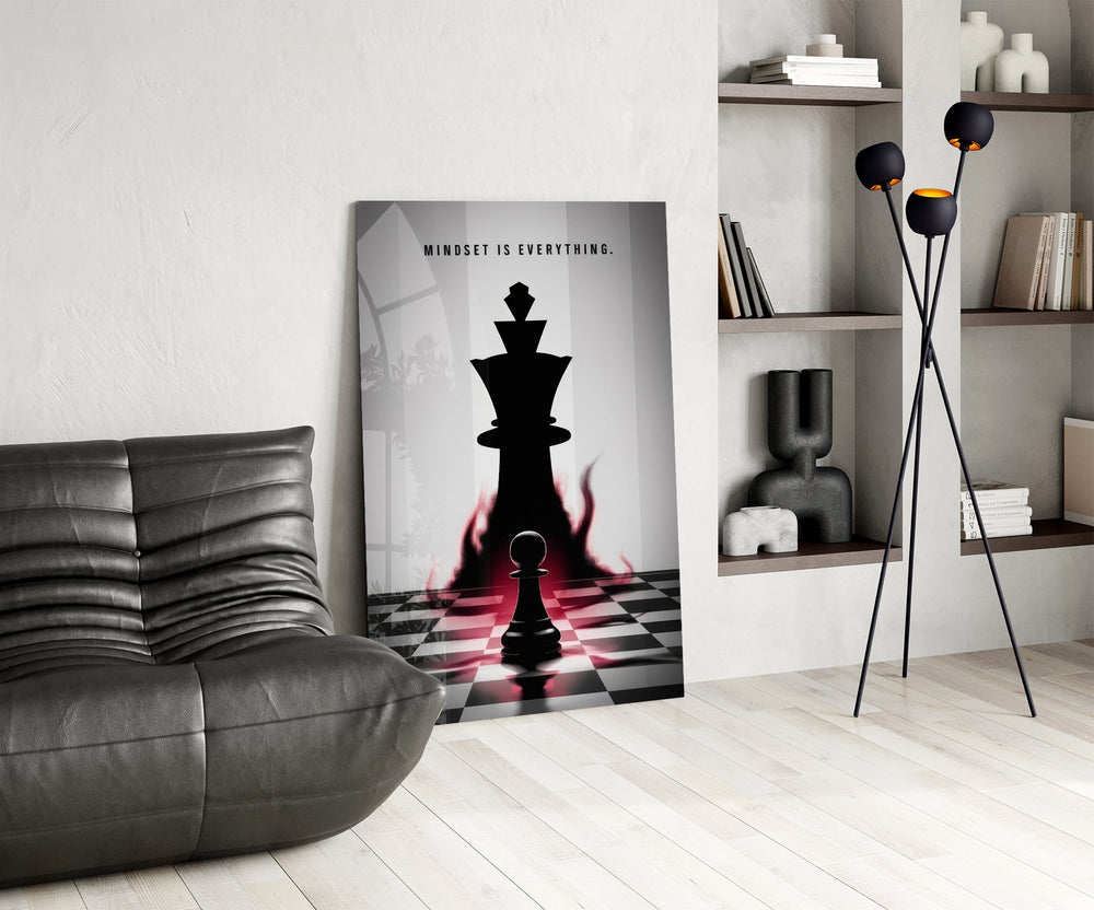a pawn facing a king-sized shadow glass wall art leaning beside a dark leather sofa