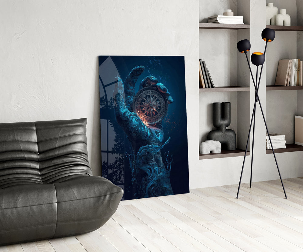 liquid water hand holding an ornate compass glass wall art leaning beside a dark leather sofa