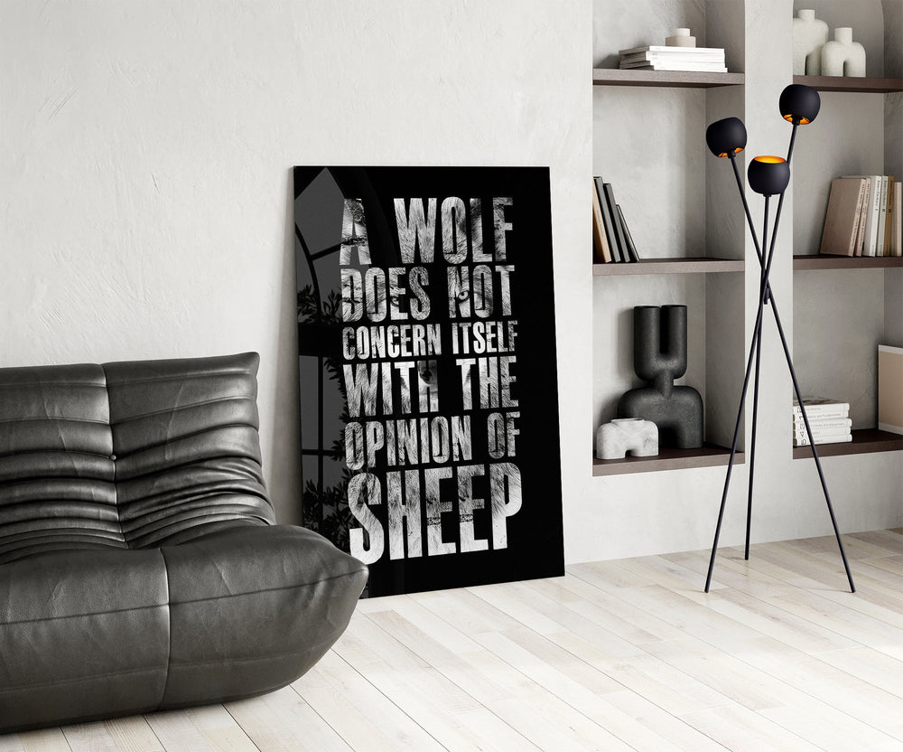 wolf opinion of sheep quote glass wall art leaning beside a dark leather sofa