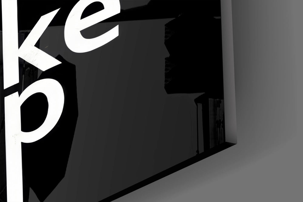 Close-up detail of the white type interlocked along thin vertical lines on the glass surface