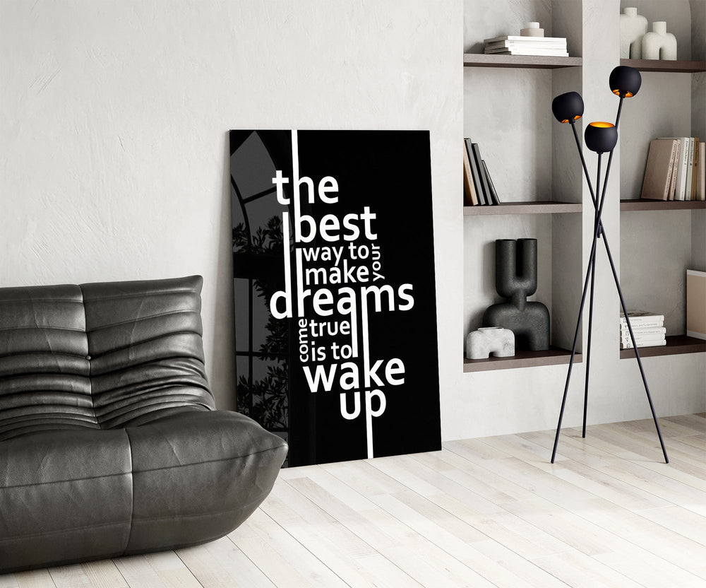 wake up dreams quote in black and white glass wall art leaning beside a dark leather sofa