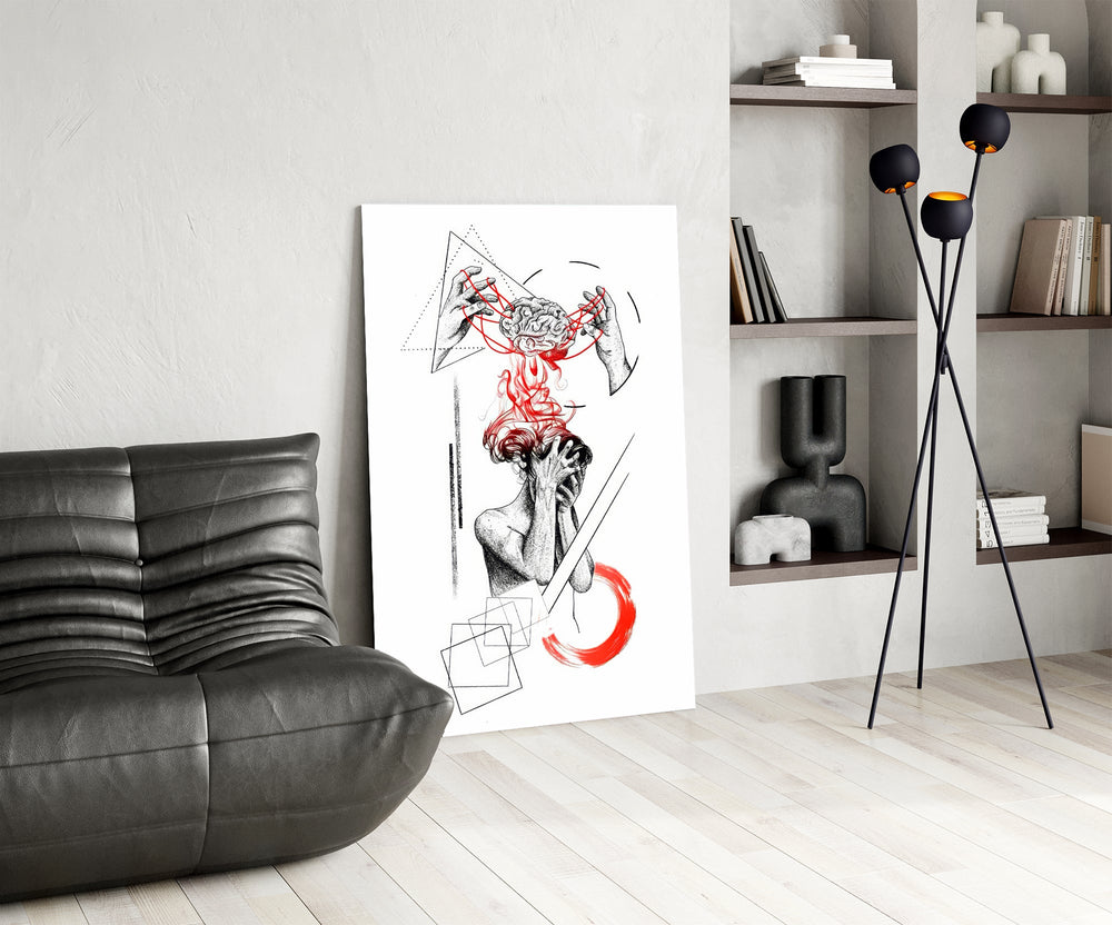 brain unravelling into red threads glass wall art leaning beside a dark leather sofa