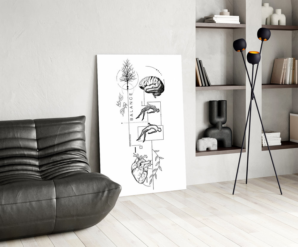 surreal balance collage of brain and heart glass wall art leaning beside a dark leather sofa
