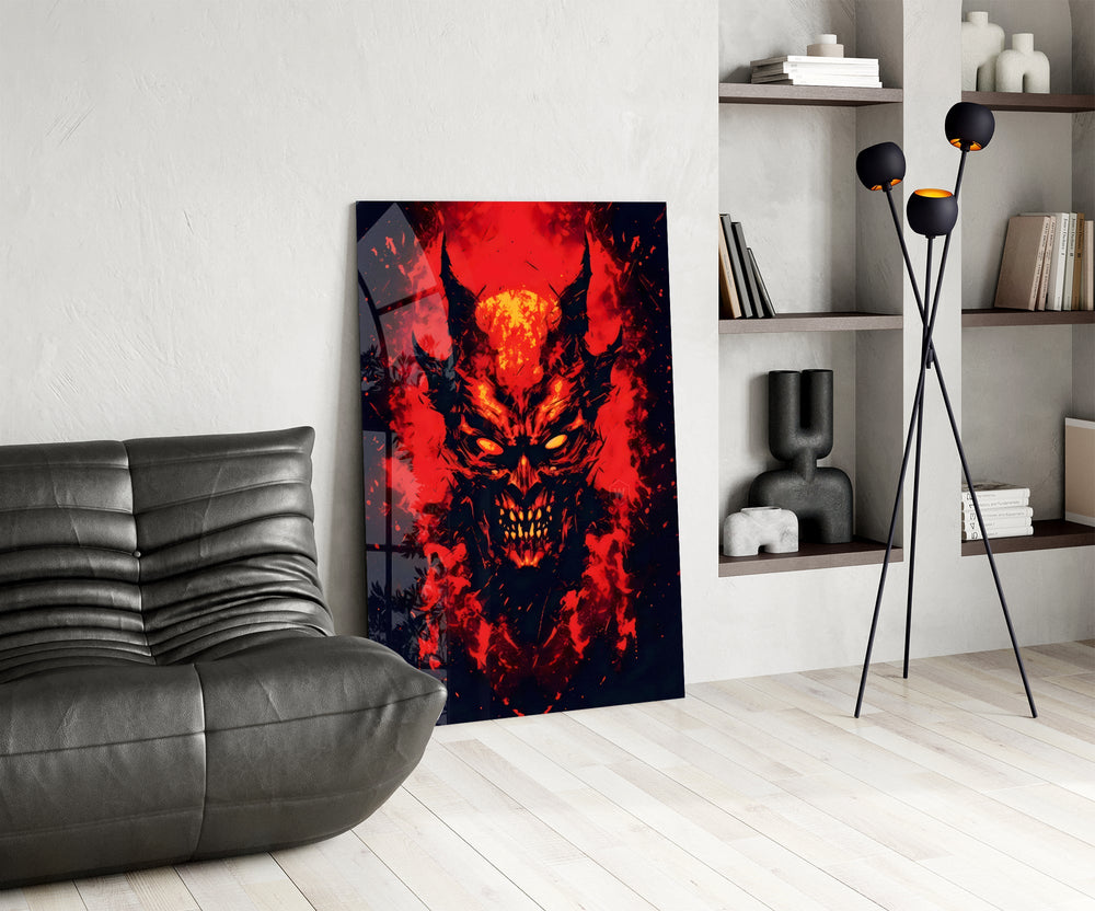 a horned demon face burning out of red flame glass wall art leaning beside a dark leather sofa