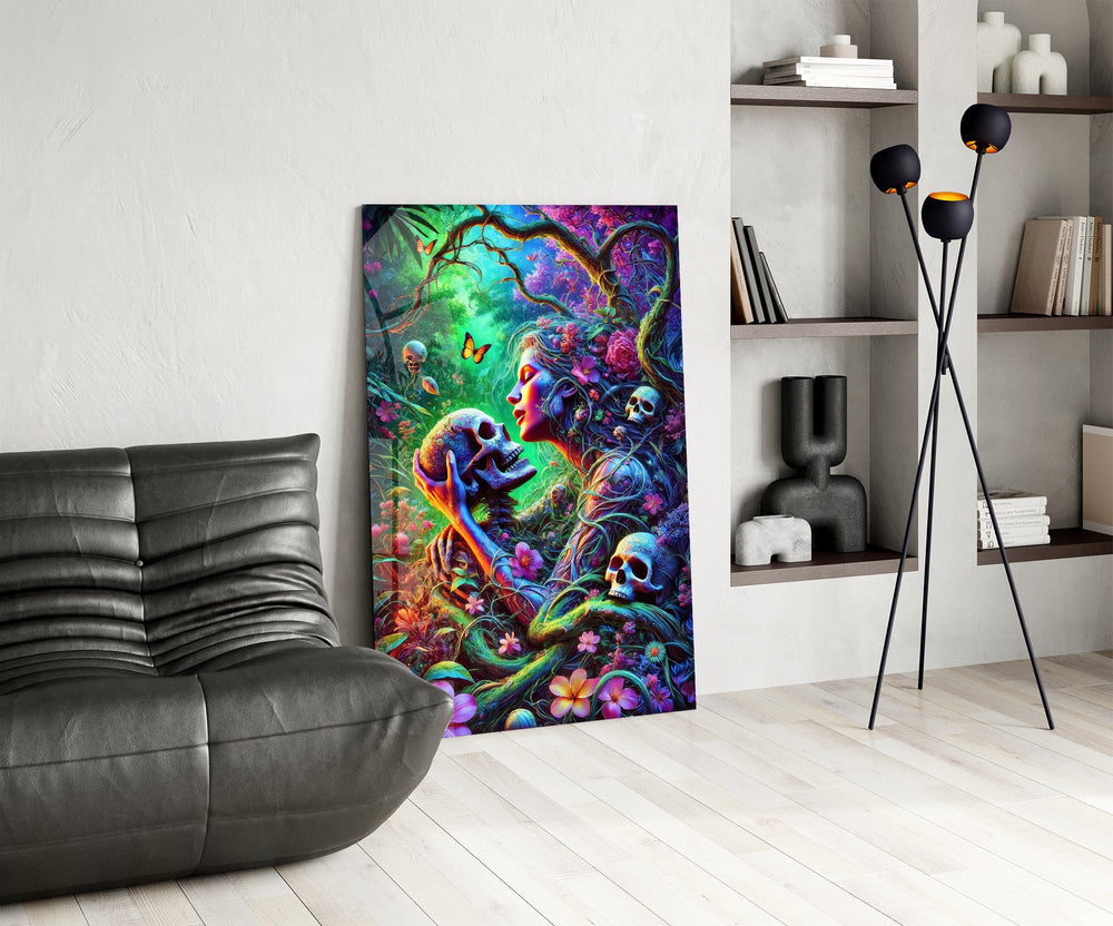 a neon jungle flower goddess holding a skull glass wall art leaning beside a dark leather sofa