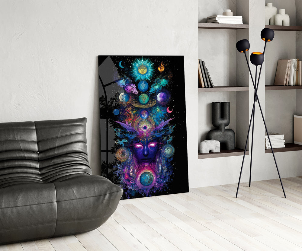 a cosmic deity crowned with planets glass wall art leaning beside a dark leather sofa