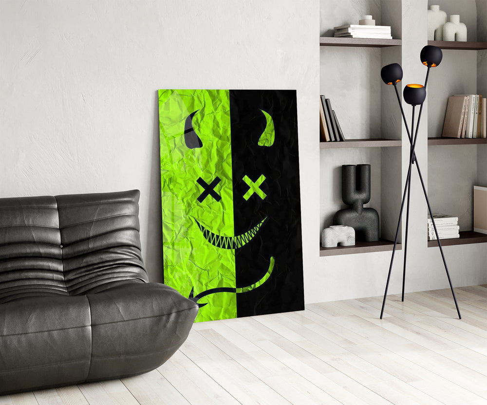 split neon green devil smiley glass wall art leaning beside a dark leather sofa
