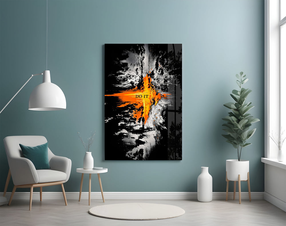 orange lava rift and lone figure glass wall art styled above an armchair in a reading corner