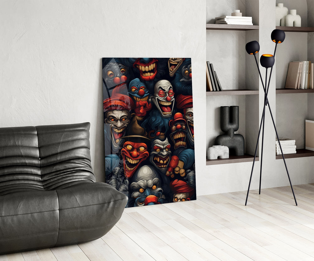grinning dark carnival clown faces glass wall art leaning beside a dark leather sofa
