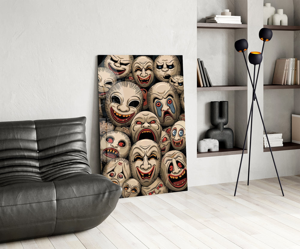 stacked sepia theatre masks glass wall art leaning beside a dark leather sofa