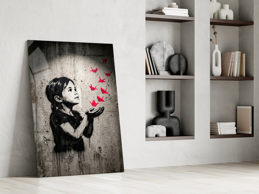 stencil girl releasing red paper cranes panel resting in a shelving niche in a modern interior