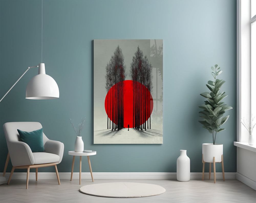 crimson sun behind bare poplars glass wall art styled above an armchair in a reading corner