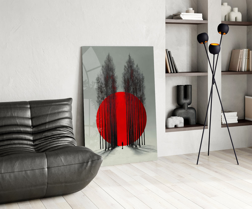 crimson sun behind bare poplars glass wall art leaning beside a dark leather sofa
