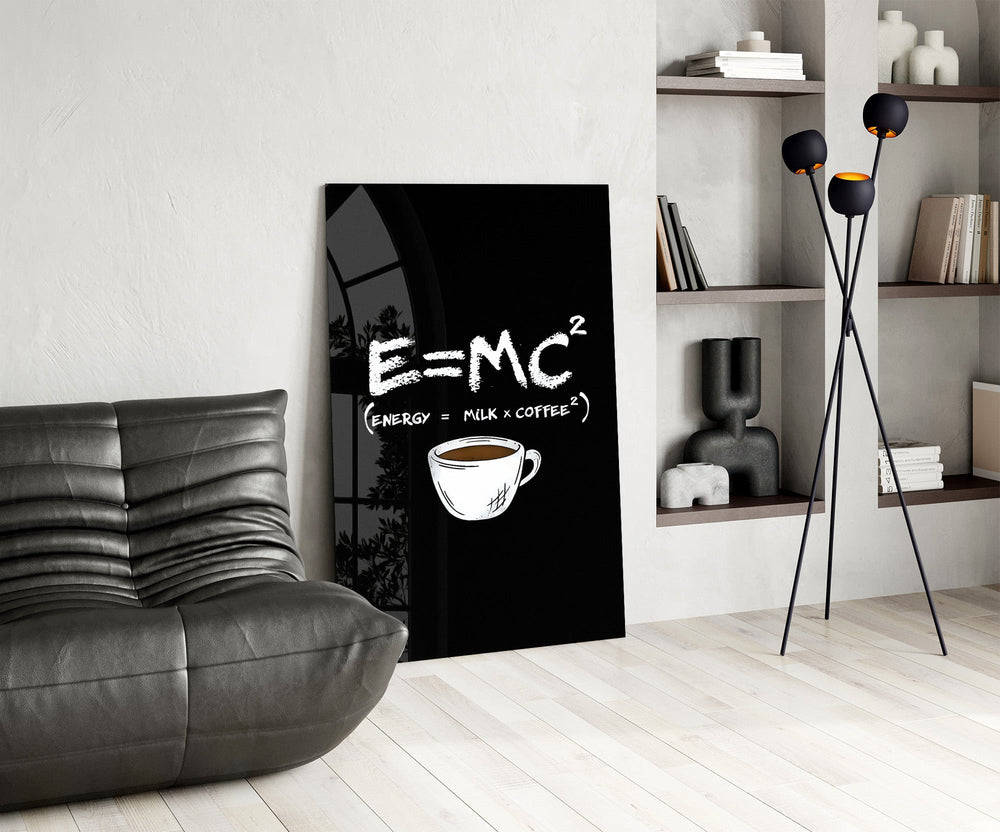 coffee energy formula humor glass wall art leaning beside a dark leather sofa