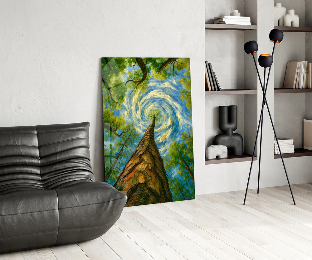 swirling sky through a treetop canopy glass wall art leaning beside a dark leather sofa