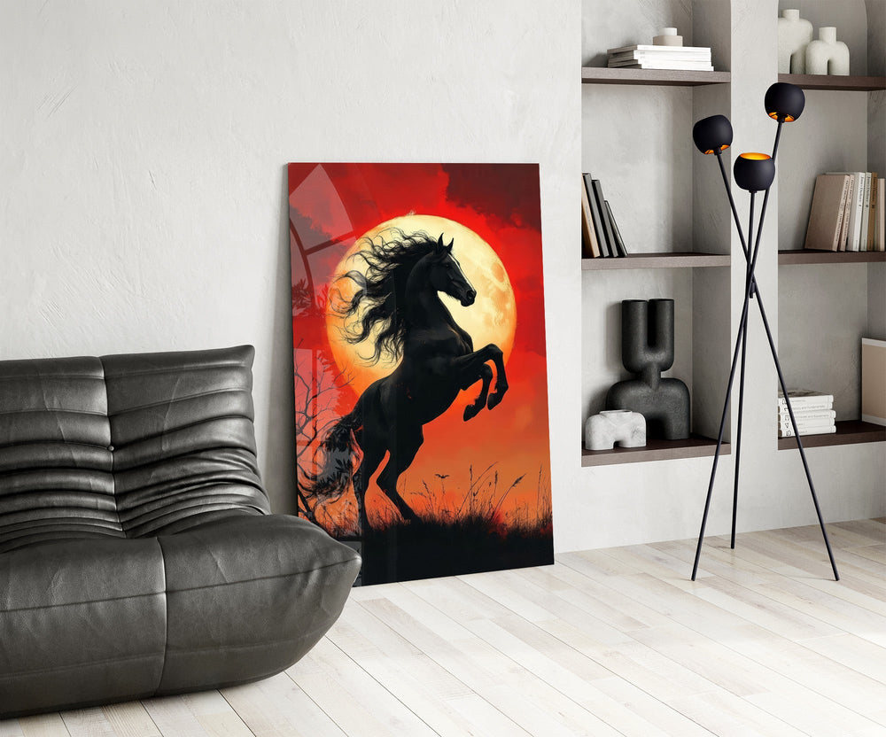 a rearing black horse under a red moon glass wall art leaning beside a dark leather sofa
