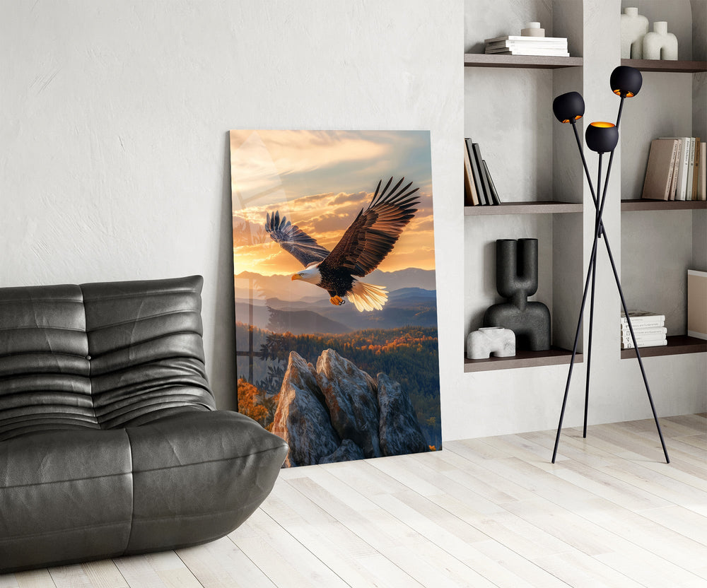 a bald eagle over autumn mountains at sunset glass wall art leaning beside a dark leather sofa