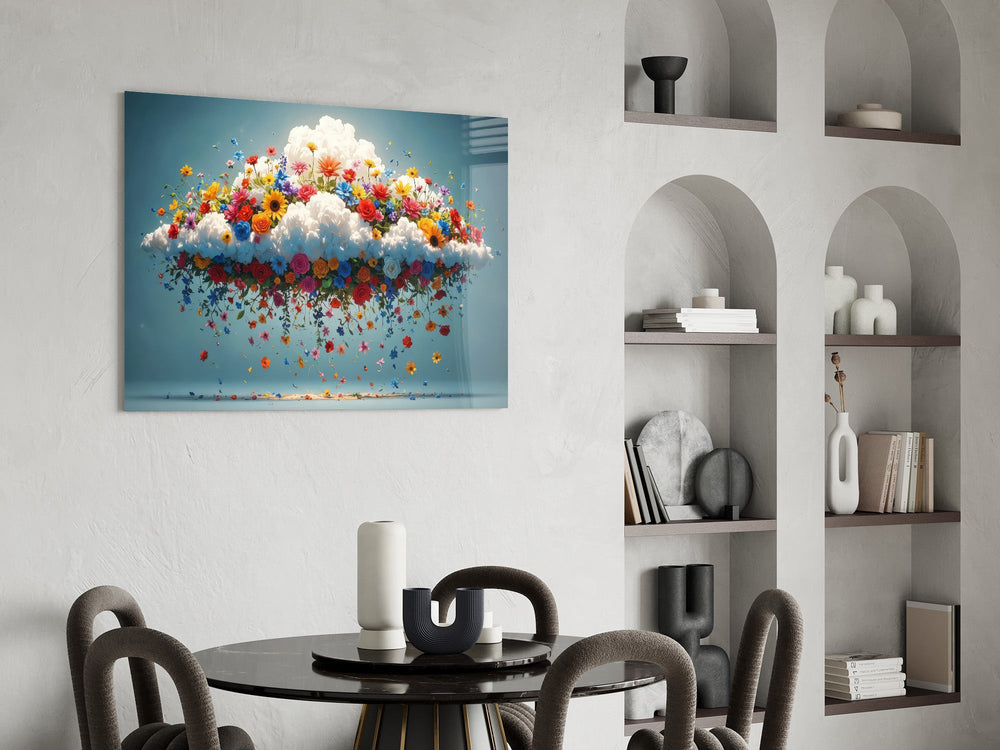 a white cloud bursting with colorful wildflowers glass wall art leaning beside a dark leather sofa