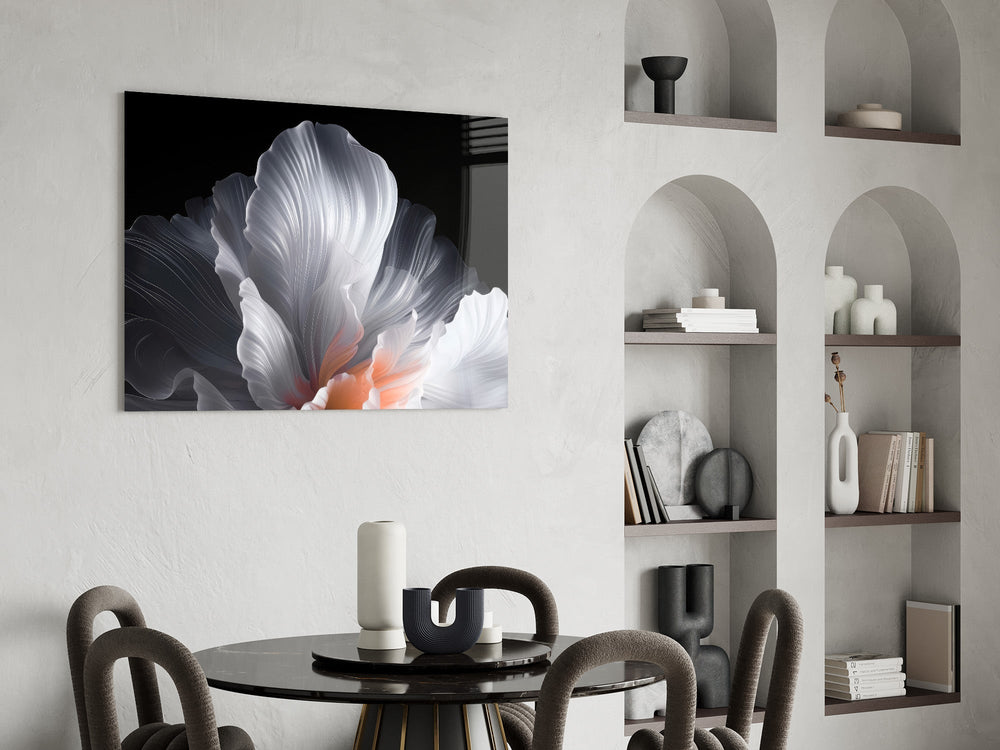 an abstract white flower on black glass wall art leaning beside a dark leather sofa