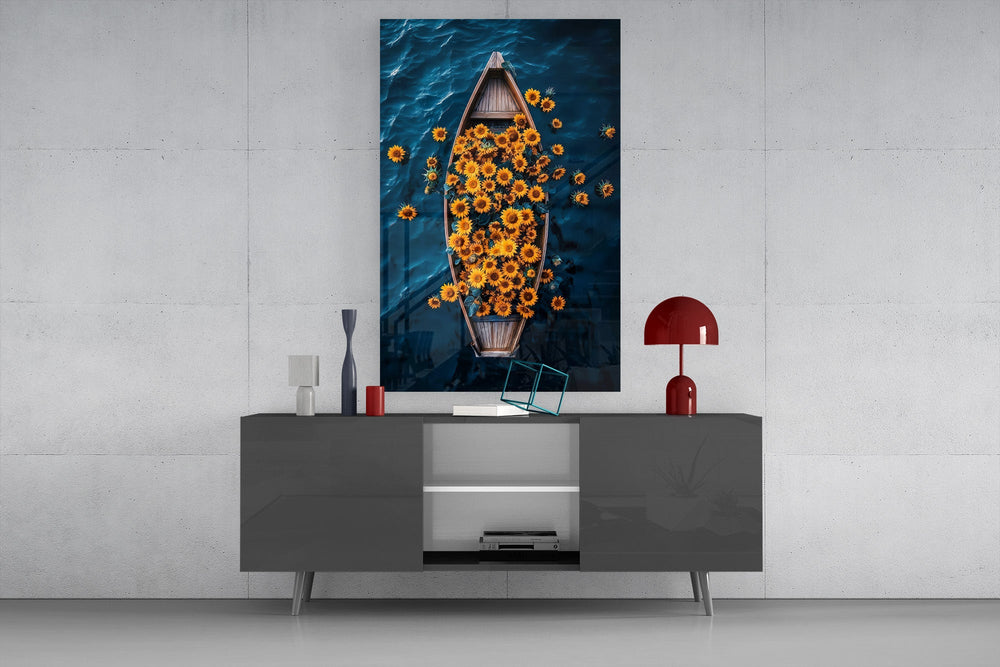 a wooden rowboat full of sunflowers on dark water glass wall art styled in an atmospheric room setting
